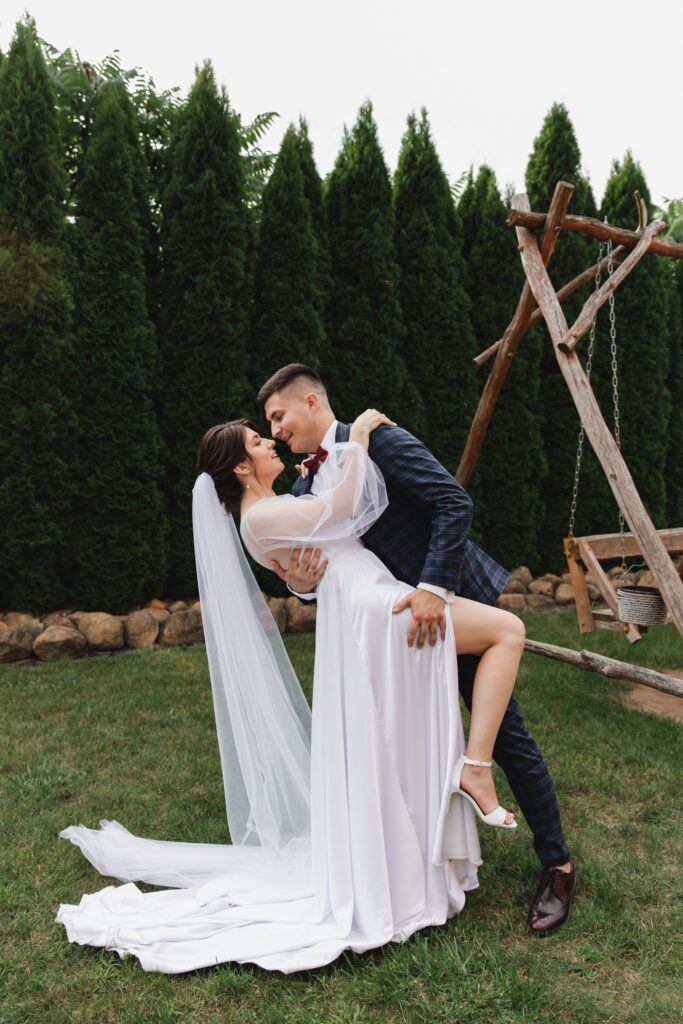 Bride and groom in a joyful outdoor embrace on their wedding day.